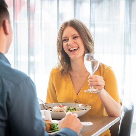 Maldron Hotel Glasgow City Exterior foto A woman laughing with a man while eating in a restaurant.