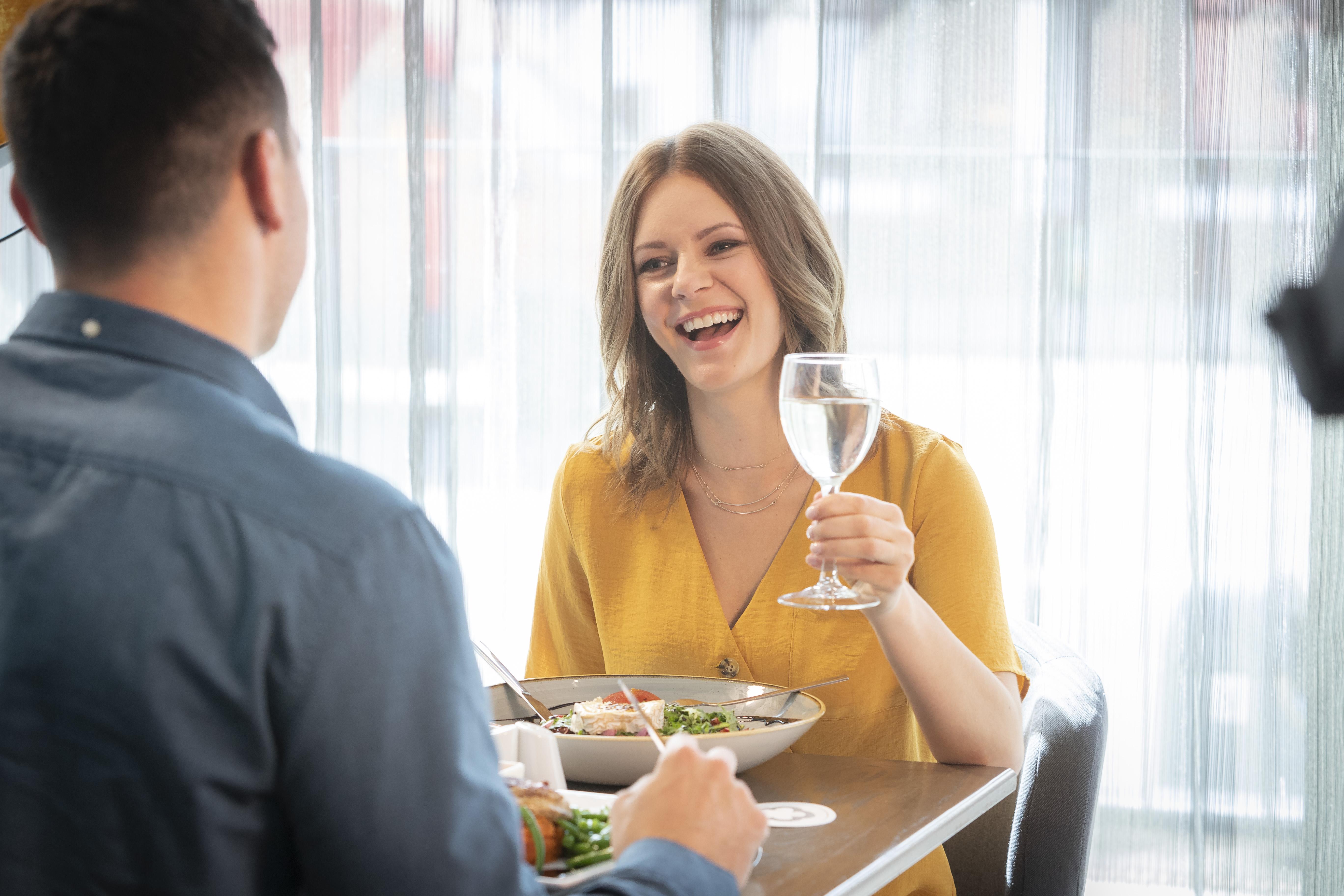 Maldron Hotel Glasgow City Exterior foto A woman laughing with a man while eating in a restaurant.